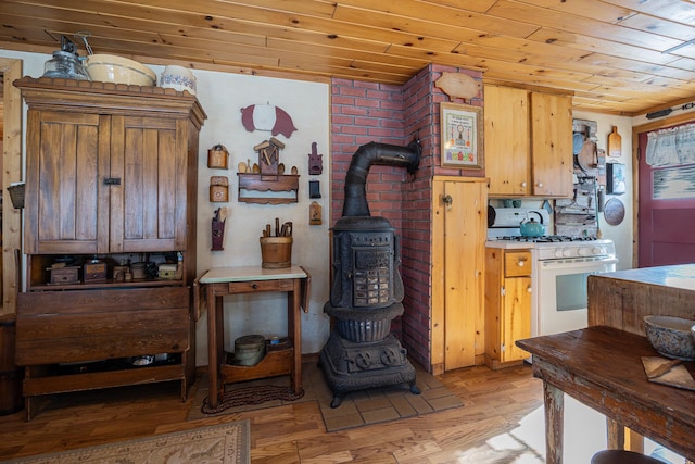 2170 County 5 NW, Hackensack, MN 56452 - kitchen featuring white gas range, a wood stove, wooden ceiling, and light wood finished floors
