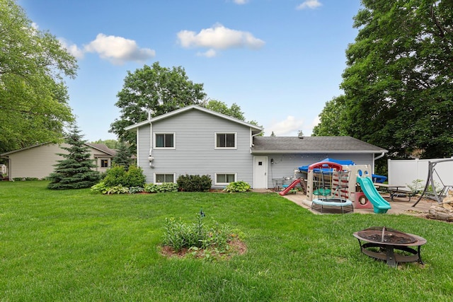 1030 Barron Rd, Faribault, MN 55021 - rear view of house with an outdoor fire pit, a playground, and a yard