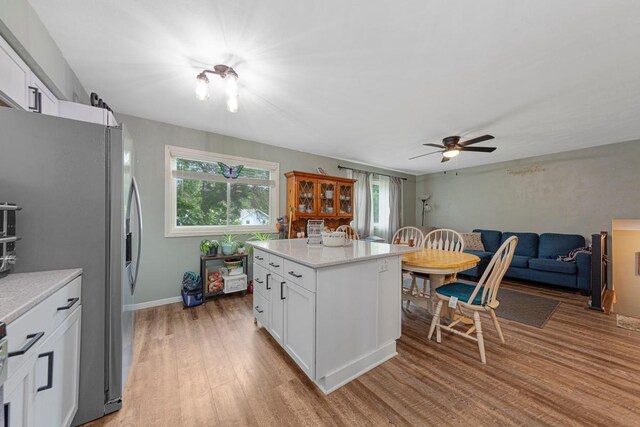 1030 Barron Rd, Faribault, MN 55021 - kitchen with freestanding refrigerator, light wood finished floors, white cabinets, a ceiling fan, and open floor plan
