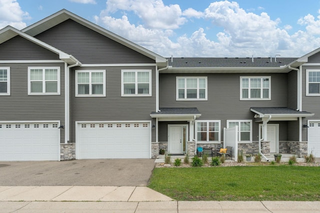 422 Ford St E, Northfield, MN 55057 - view of front of house with driveway, stone siding, a front yard, and a garage