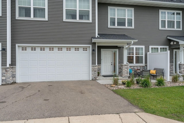 422 Ford St E, Northfield, MN 55057 - view of front of property featuring stone siding, an attached garage, and driveway