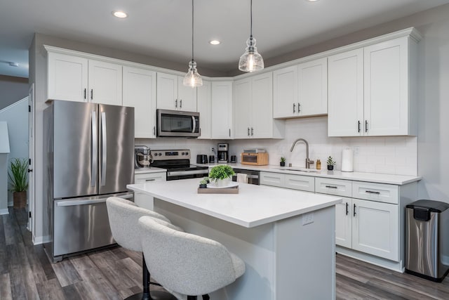422 Ford St E, Northfield, MN 55057 - kitchen featuring appliances with stainless steel finishes, dark wood-style floors, white cabinets, decorative backsplash, and recessed lighting