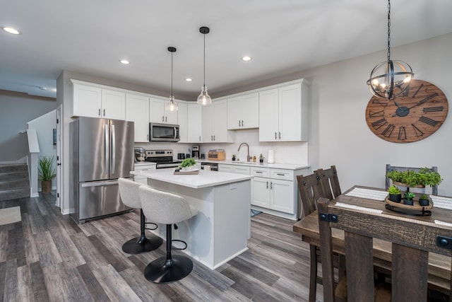 422 Ford St E, Northfield, MN 55057 - kitchen featuring appliances with stainless steel finishes, dark wood-type flooring, light countertops, recessed lighting, and white cabinets