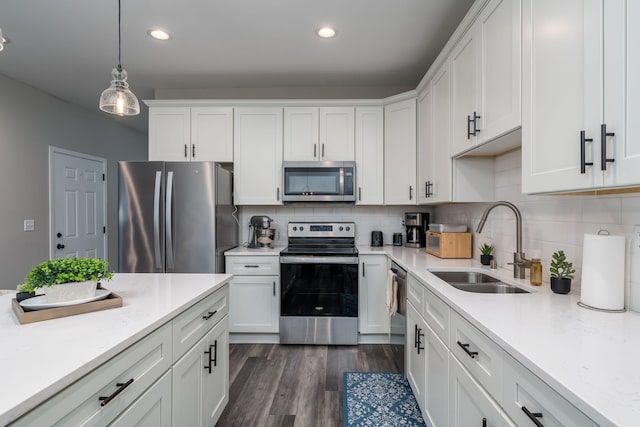 422 Ford St E, Northfield, MN 55057 - kitchen featuring stainless steel appliances, white cabinets, tasteful backsplash, hanging light fixtures, and recessed lighting