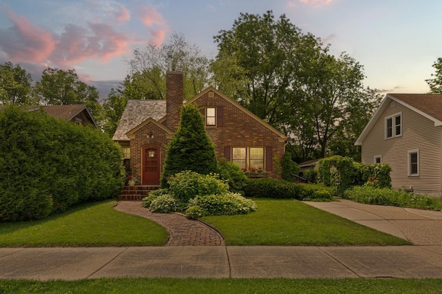 825 5th Ave SW, Faribault, MN 55021 - view of front of property featuring a yard, brick siding, and a chimney