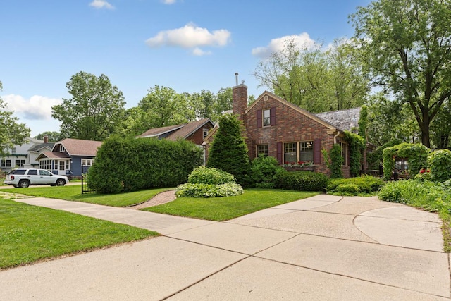 825 5th Ave SW, Faribault, MN 55021 - view of front of house with brick siding, a chimney, and a front yard
