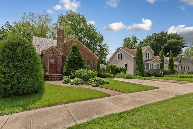 825 5th Ave SW, Faribault, MN 55021 - english style home with brick siding, a front yard, and a chimney
