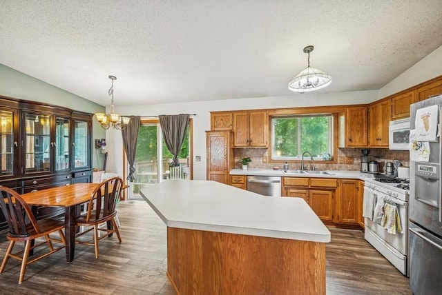 26343 10th St W, Zimmerman, MN 55398 - kitchen with stainless steel appliances, a chandelier, a textured ceiling, brown cabinetry, and light countertops