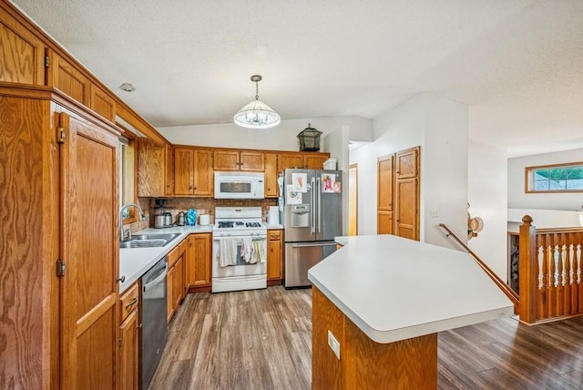 26343 10th St W, Zimmerman, MN 55398 - kitchen with appliances with stainless steel finishes, wood finished floors, light countertops, brown cabinets, and lofted ceiling