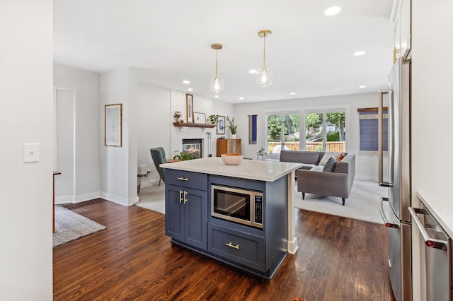 4810 42nd St, Saint Louis Park, MN 55416 - kitchen with open floor plan, appliances with stainless steel finishes, dark wood-style floors, light countertops, and a fireplace