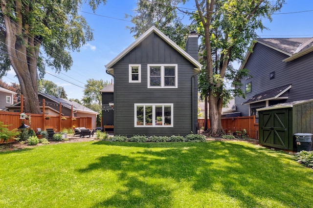 4810 42nd St, Saint Louis Park, MN 55416 - back of house with board and batten siding, a shed, a fenced backyard, a chimney, and a patio area