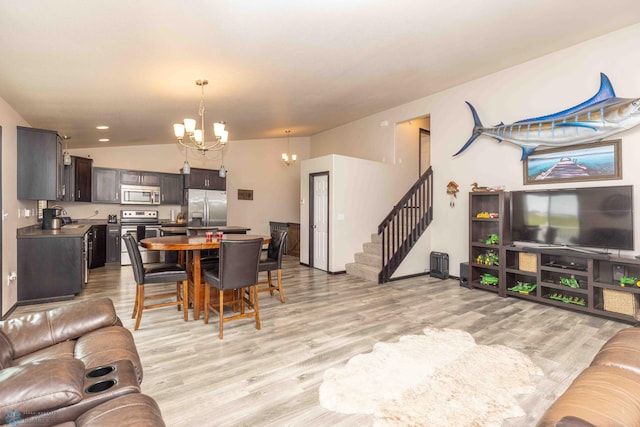 618 23rd Ave W, West Fargo, ND 58078 - living room featuring a chandelier, light wood-type flooring, vaulted ceiling, and stairway