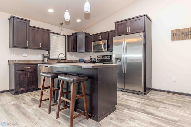 618 23rd Ave W, West Fargo, ND 58078 - kitchen featuring stainless steel appliances, dark brown cabinetry, a kitchen island, vaulted ceiling, and light wood-style floors