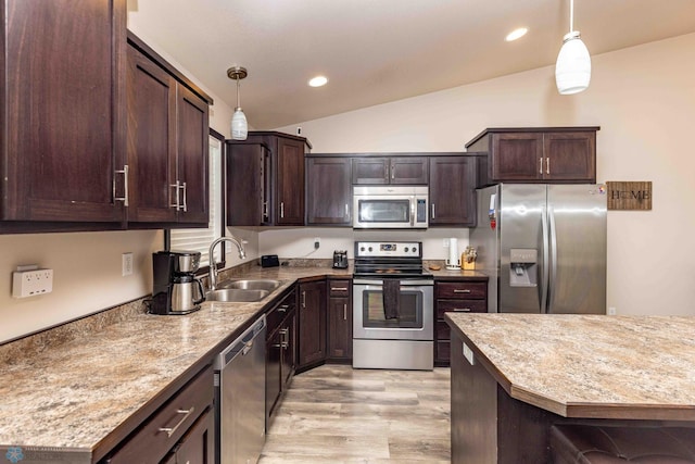 618 23rd Ave W, West Fargo, ND 58078 - kitchen with appliances with stainless steel finishes, lofted ceiling, dark brown cabinetry, pendant lighting, and light wood-style flooring