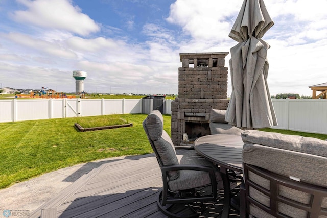 618 23rd Ave W, West Fargo, ND 58078 - deck featuring an outdoor stone fireplace and a fenced backyard