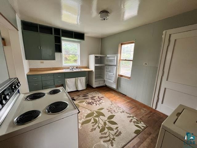 355 Harvey St, Ely, MN 55731 - kitchen featuring white range with electric cooktop, healthy amount of natural light, green cabinets, and light wood-style floors