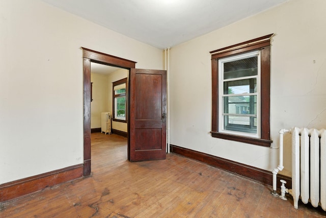 976 Forest St, Saint Paul, MN 55106 - empty room featuring radiator and hardwood / wood-style floors
