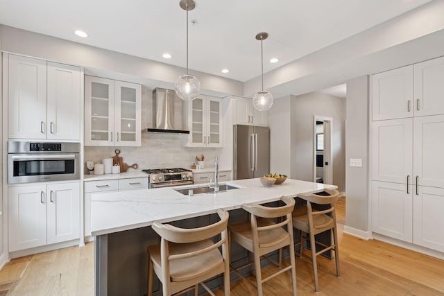 2820 Saint Louis Ave, Minneapolis, MN 55416 - kitchen featuring wall chimney range hood, stainless steel appliances, light wood finished floors, white cabinetry, and recessed lighting