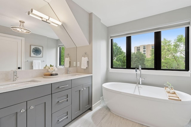 2820 Saint Louis Ave, Minneapolis, MN 55416 - bathroom featuring double vanity, marble look tiles, a soaking tub, and healthy amount of natural light