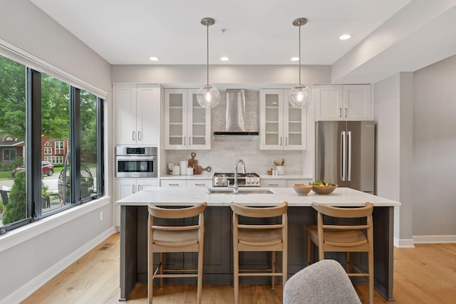 2820 Saint Louis Ave, Minneapolis, MN 55416 - kitchen with appliances with stainless steel finishes, wall chimney exhaust hood, white cabinetry, decorative backsplash, and light wood-type flooring