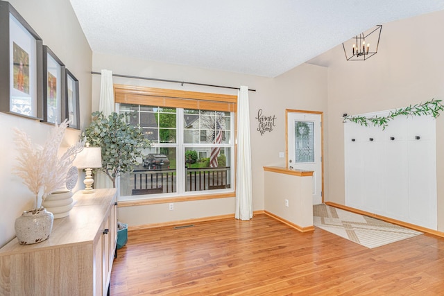 15265 Dupont Path, Apple Valley, MN 55124 - entryway with light wood-style floors, a chandelier, and a textured ceiling
