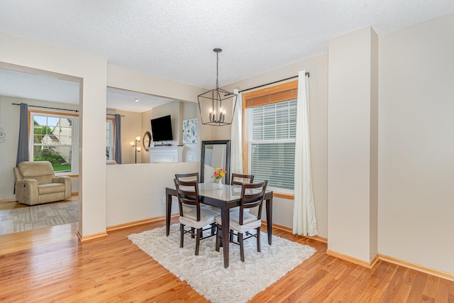 15265 Dupont Path, Apple Valley, MN 55124 - dining space with a chandelier, light wood-style flooring, and a textured ceiling