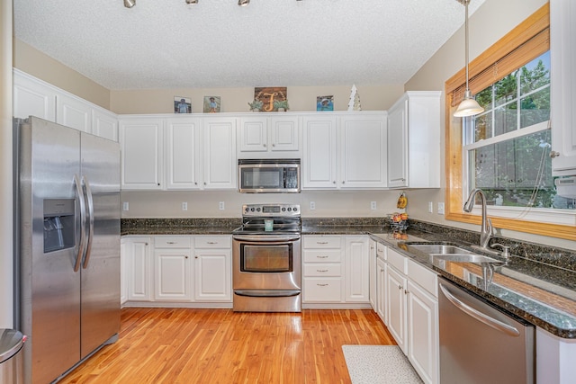 15265 Dupont Path, Apple Valley, MN 55124 - kitchen with appliances with stainless steel finishes, white cabinets, hanging light fixtures, light wood-style floors, and a textured ceiling