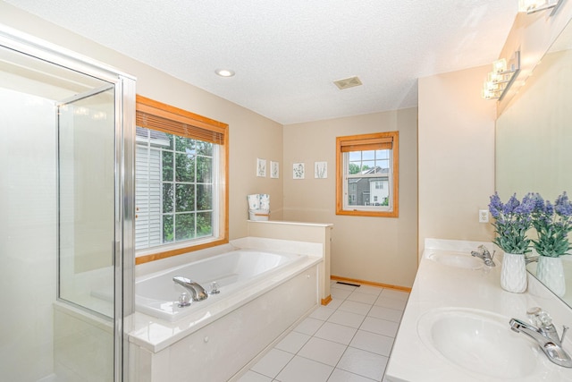 15265 Dupont Path, Apple Valley, MN 55124 - bathroom featuring plenty of natural light, a textured ceiling, a bath, double vanity, and tile patterned floors