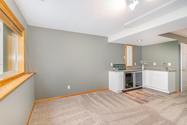 15265 Dupont Path, Apple Valley, MN 55124 - indoor wet bar featuring beverage cooler, light colored carpet, and a textured ceiling
