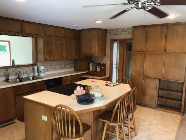 300 Whittier St W, Lanesboro, MN 55949 - kitchen featuring ceiling fan, a kitchen island, light countertops, a breakfast bar, and dishwasher