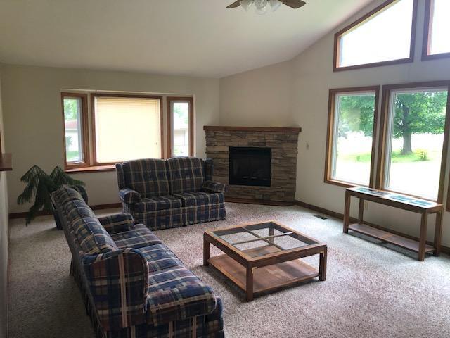 300 Whittier St W, Lanesboro, MN 55949 - carpeted living room with healthy amount of natural light, ceiling fan, a fireplace, and high vaulted ceiling