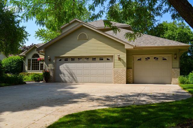 559 Lonesome Pine Trl, Lino Lakes, MN 55014 - view of front of home with an attached garage, driveway, brick siding, and a shingled roof