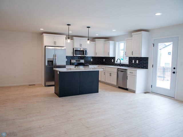 7901 Lost River Rd, Horace, ND 58047 - kitchen featuring stainless steel appliances, a kitchen island, tasteful backsplash, white cabinetry, and recessed lighting