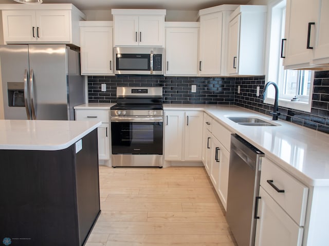 7901 Lost River Rd, Horace, ND 58047 - kitchen featuring stainless steel appliances, light wood finished floors, light countertops, and white cabinets