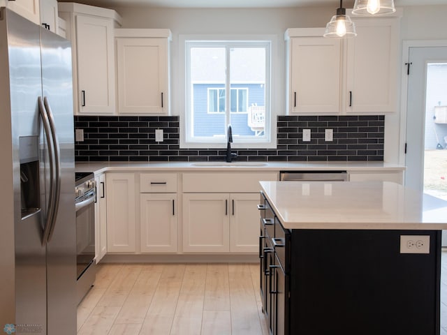 7901 Lost River Rd, Horace, ND 58047 - kitchen with appliances with stainless steel finishes, plenty of natural light, backsplash, and white cabinets