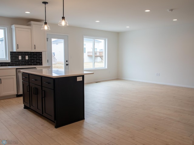 7901 Lost River Rd, Horace, ND 58047 - kitchen featuring stainless steel dishwasher, white cabinets, light countertops, backsplash, and light wood finished floors