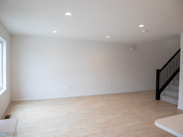 7901 Lost River Rd, Horace, ND 58047 - unfurnished living room featuring light wood-style flooring, plenty of natural light, stairway, and recessed lighting