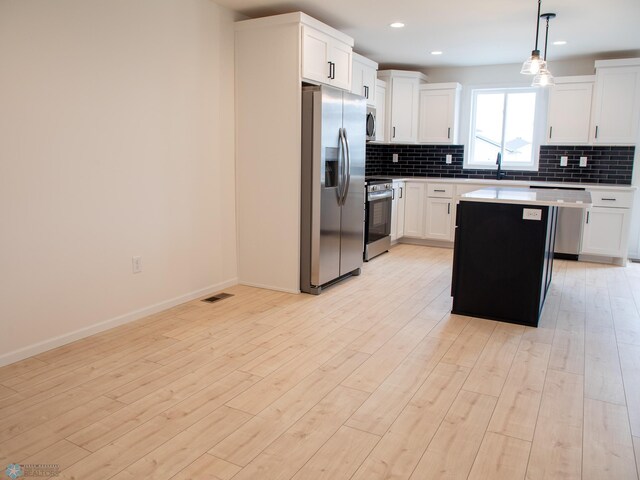 7901 Lost River Rd, Horace, ND 58047 - kitchen featuring stainless steel appliances, backsplash, light countertops, a kitchen island, and recessed lighting