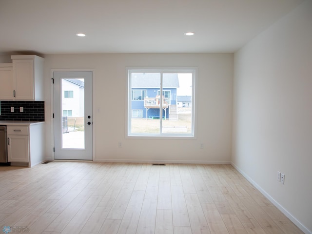 7901 Lost River Rd, Horace, ND 58047 - kitchen with white cabinets, light wood-type flooring, backsplash, stainless steel dishwasher, and recessed lighting
