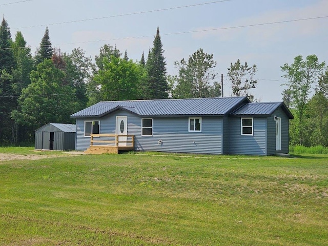 10091 Trengove Rd NW, Bemidji, MN 56601 - view of front of house with a shed, a front yard, a metal roof, and a deck