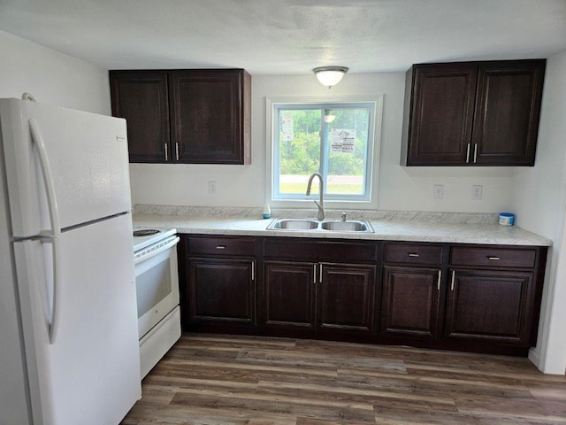 10091 Trengove Rd NW, Bemidji, MN 56601 - kitchen with white appliances, dark brown cabinetry, and light countertops