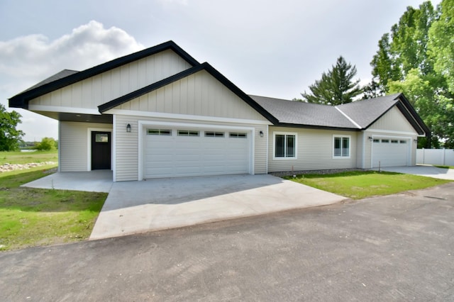 3231/2UNIT3 Fairgrounds Rd N, Alexandria, MN 56308 - view of front of house featuring an attached garage, driveway, board and batten siding, and a front yard