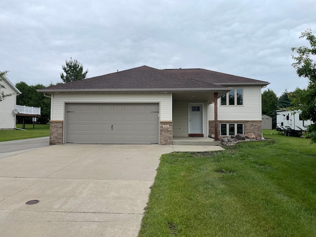 306 10th Ave NW, Dodge Center, MN 55927 - view of front of house featuring brick siding, concrete driveway, a front yard, a garage, and a shingled roof