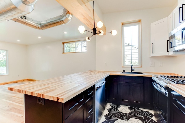 3909 Xerxes Ave S, Minneapolis, MN 55410 - kitchen featuring wood counters, appliances with stainless steel finishes, white cabinets, recessed lighting, and a peninsula