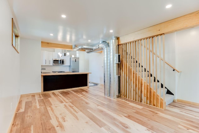 3909 Xerxes Ave S, Minneapolis, MN 55410 - kitchen featuring stainless steel microwave, white cabinets, light wood finished floors, recessed lighting, and a chandelier