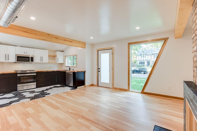 3909 Xerxes Ave S, Minneapolis, MN 55410 - kitchen featuring stainless steel appliances, white cabinetry, healthy amount of natural light, open shelves, and beamed ceiling