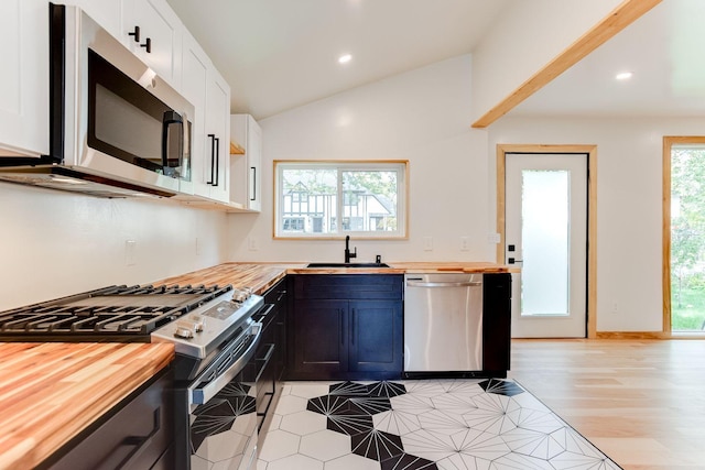 3909 Xerxes Ave S, Minneapolis, MN 55410 - kitchen featuring wood counters, stainless steel appliances, lofted ceiling, recessed lighting, and white cabinets