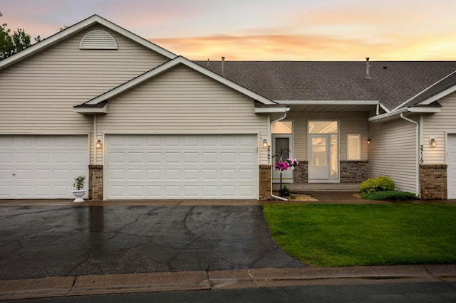 2721 230th Ct NW, Saint Francis, MN 55070 - view of front facade with brick siding, asphalt driveway, a lawn, an attached garage, and a shingled roof