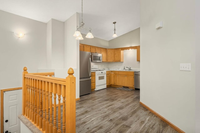 2721 230th Ct NW, Saint Francis, MN 55070 - kitchen featuring stainless steel appliances, light countertops, dark wood-type flooring, lofted ceiling, and decorative light fixtures