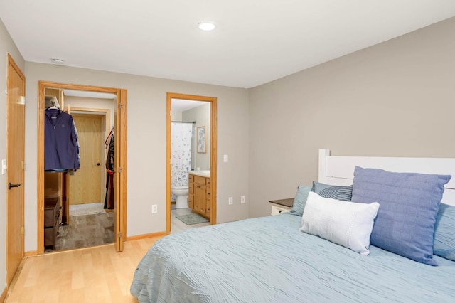 2721 230th Ct NW, Saint Francis, MN 55070 - bedroom with light wood-style floors, a walk in closet, recessed lighting, connected bathroom, and a closet
